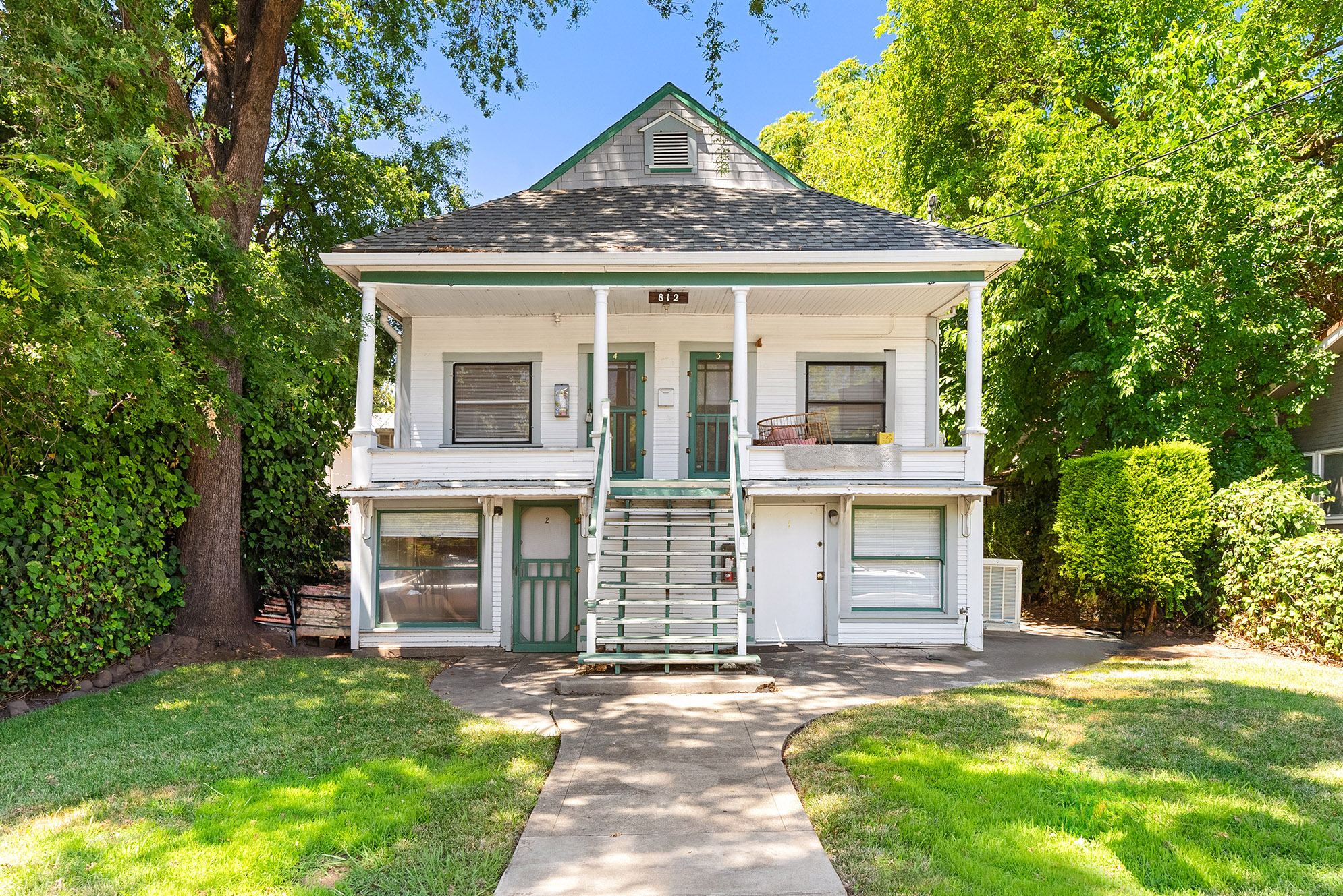 Front of 812 House, a classic two-story fourplex with a big lawn